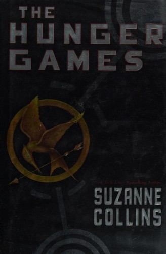Cover of the Scholastic hardcover edition of The Hunger Games by Suzanne Collins, showing a golden mockingjay pin on a black background.